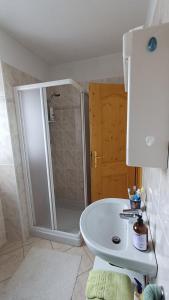 a bathroom with a shower and a white sink at Sambor apartment in Oga