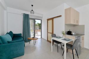 a living room with a blue couch and a table at SunDay Free Airport Shuttle in Artemida