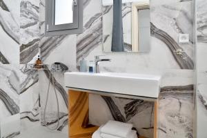 a bathroom with a sink and a mirror at SunDay Free Airport Shuttle in Artemida +29 photos