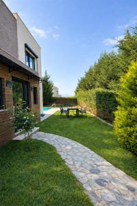 a garden with a table and benches in the grass at Villa Dream in Kuşadası