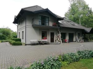 a small house with a balcony and a patio at Zofijówka in Osjaków