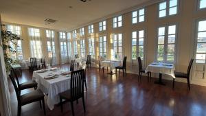 a dining room with tables and chairs and windows at Hotel Palacio de las Nieves in Langreo