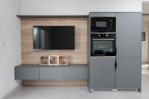 a entertainment center with a flat screen tv on a wall at Villa Maris in Povlja
