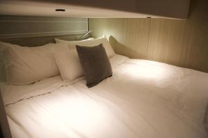 a large white bed with white pillows in a room at MYTH bay in Bandar Jişşah