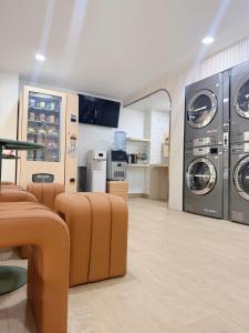 a laundry room with washers and dryers in a store at Wynora Hotel in Klong Toi
