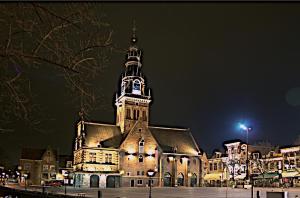 a large building with a clock tower at night at Hotel Stad en Land in Alkmaar