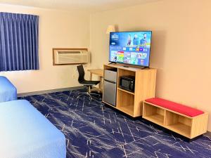 a hotel room with a television and a bed at Super 8 by Wyndham Hot Springs in Hot Springs
