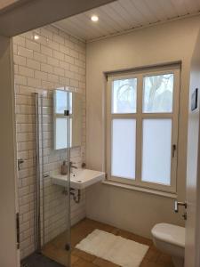 a bathroom with a sink and a toilet and a window at Ferienhaus an der Allee in Kalkar +39 photos