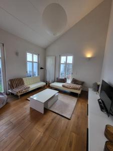 a living room with two couches and a tv at Ferienhaus an der Allee in Kalkar