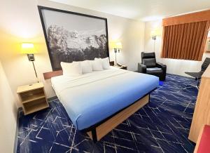 a hotel room with a large bed and a chair at Super 8 by Wyndham Hot Springs in Hot Springs +32 photos
