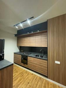 a kitchen with wooden cabinets and a sink at Well House Cozy 2BR in Tbilisi City