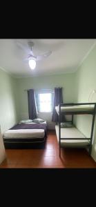 a bedroom with two bunk beds and a ceiling fan at Residêncial Allah in Peruíbe