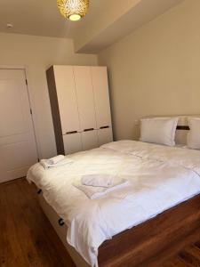 a bedroom with a large bed with white sheets at Well House Cozy 2BR in Tbilisi City +4 photos