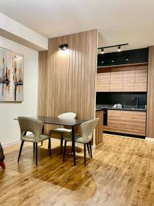 a dining room with a table and chairs and a kitchen at Well House Cozy 2BR in Tbilisi City