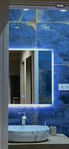 a bathroom with a sink and a blue tile wall at Well House Cozy 2BR in Tbilisi City