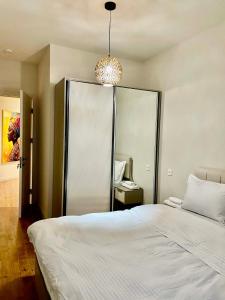 a bedroom with a large bed and a mirror at Well House Cozy 2BR in Tbilisi City