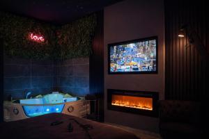 a bathroom with a tub and a tv over a fireplace at Loft, Studio and Love Rooms in Bourg-Saint-Christophe