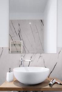 a bathroom with a white sink and a marble wall at Il Giardino di Gioia in Verona