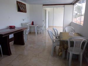 a dining room with white chairs and a table at Casa condomínio clube in Araruama