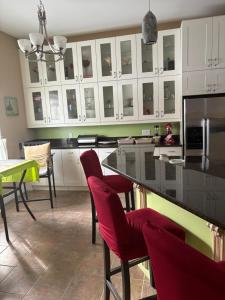 a kitchen with a black counter and red chairs at Lakeview in Colborne +5 photos