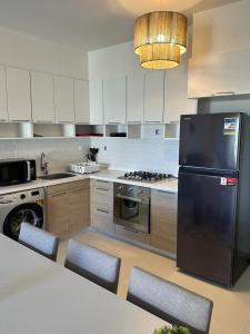 a kitchen with a refrigerator and a table and chairs at Marina Marassi in El Alamein