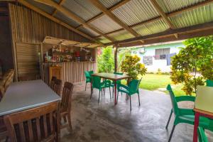 a patio with green chairs and a table and a table at Wli Waterfalls Inn,My Home Your Home in Wli Afegame