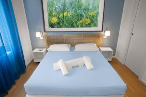 a bedroom with a white bed with two towels on it at Il Giardino di Gioia in Verona +5 photos