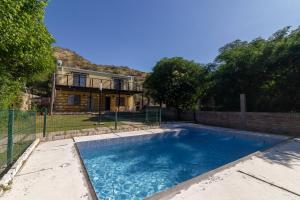 a swimming pool in front of a house at CABAÑAS EL CERRO in Ciudad Lujan de Cuyo