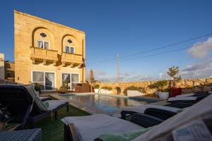 a pool with lounge chairs next to a building at Ajuga Luxury Boutique B&B in Qala