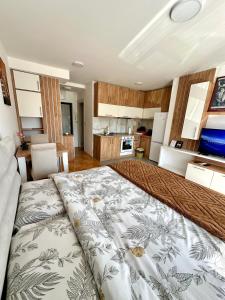 a large bed in a room with a kitchen at Vidolux Studio - Free Garage and Fast WiFi in Niš