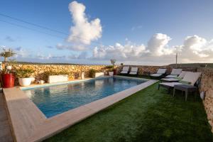 a swimming pool in the middle of a yard at Ajuga Luxury Boutique B&B in Qala