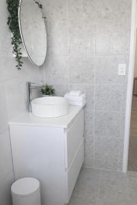 a white bathroom with a sink and a mirror at Pandora Place in Lightning Ridge +9 photos