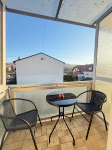a table and two chairs on a balcony with a view at Leo's Pension in Bad Schallerbach