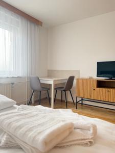 a bedroom with a bed and a table and a television at Leo's Pension in Bad Schallerbach