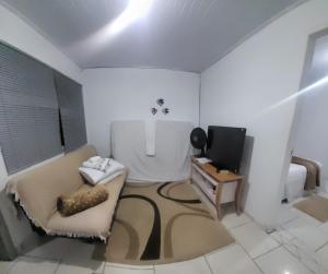 a living room with a tv and a couch and a table at paraiso da lagoa in Imbituba