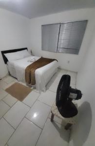 a bedroom with a bed and a chair in it at paraiso da lagoa in Imbituba