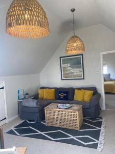 a living room with a blue couch and a table at The Nookery in Winscombe