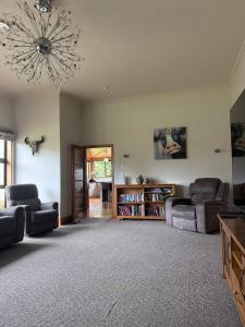 a living room with two couches and a chandelier at Rakanui Hidden Retreat in Hilderthorpe