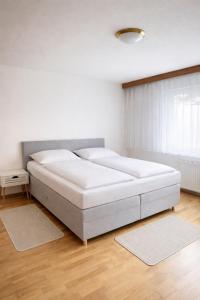 a bedroom with a large white bed in a room at Leo's Pension in Bad Schallerbach