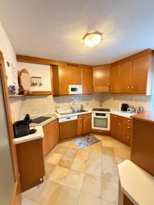 a kitchen with wooden cabinets and white appliances at Leo's Pension in Bad Schallerbach +8 photos