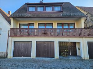 a house with a balcony on top of it at Torwirt Apartments in Herrieden