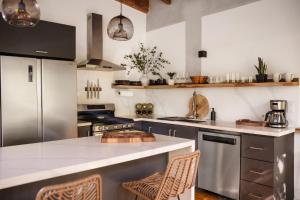 a kitchen with a counter with chairs in it at Villa Sea Breeze in West End