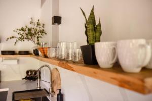 a wooden shelf with cups and plants on it at Villa Sea Breeze in West End +49 photos