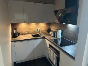 a kitchen with white cabinets and a sink at Deck 8 in Timmendorfer Strand