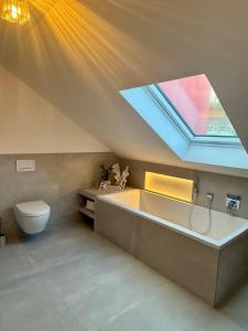 a bathroom with a bath tub and a skylight at Spessart Escape - Ihr stilvoller Rückzugsort im Herzen des Spessarts in Mespelbrunn +12 photos