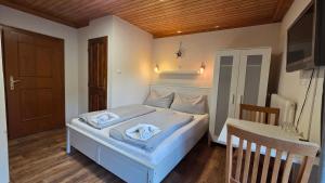 a bedroom with a bed with two towels on it at Pension Tyrol Maria Alm in Maria Alm am Steinernen Meer