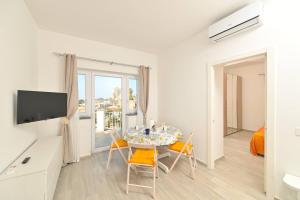 a living room with a table and chairs and a television at La Perla Sul Mare in Forio d'Ischia