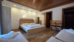 a bedroom with two beds and a table and chairs at Pension Tyrol Maria Alm in Maria Alm am Steinernen Meer