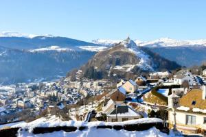 a village covered in snow with mountains in the background at Murat - La petite maison Murataise in Murat