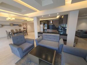 a living room with two blue chairs and a table at Prime Plaza Porto Towers Stay Hotel VIP in Ain Sokhna